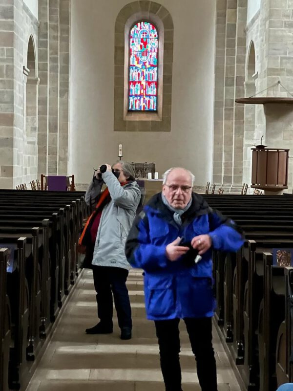 Dr. Unger erläutert die Kirche in Lippoldsberg und eine Teilnehmerin fotografiert ununterbrochen