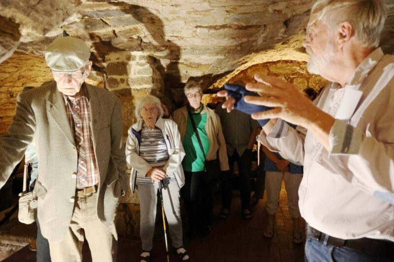 Faszinierte Teilnehmer lauschen im Kellergewölbe den Erklärungen von J. Geritzen